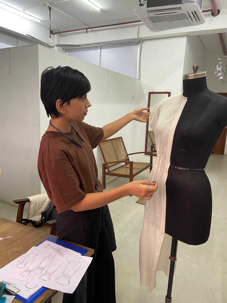 Mansi Pandey draping a linen garment on a dress form in the studio